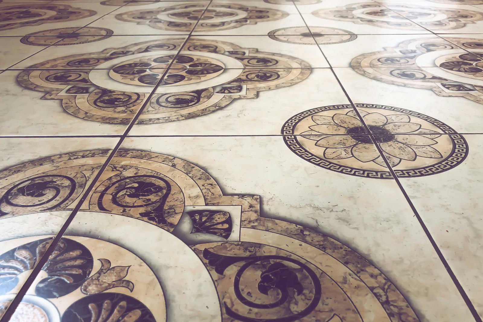 Hand mit Saugnapf hebt eine Fliese vom Boden an