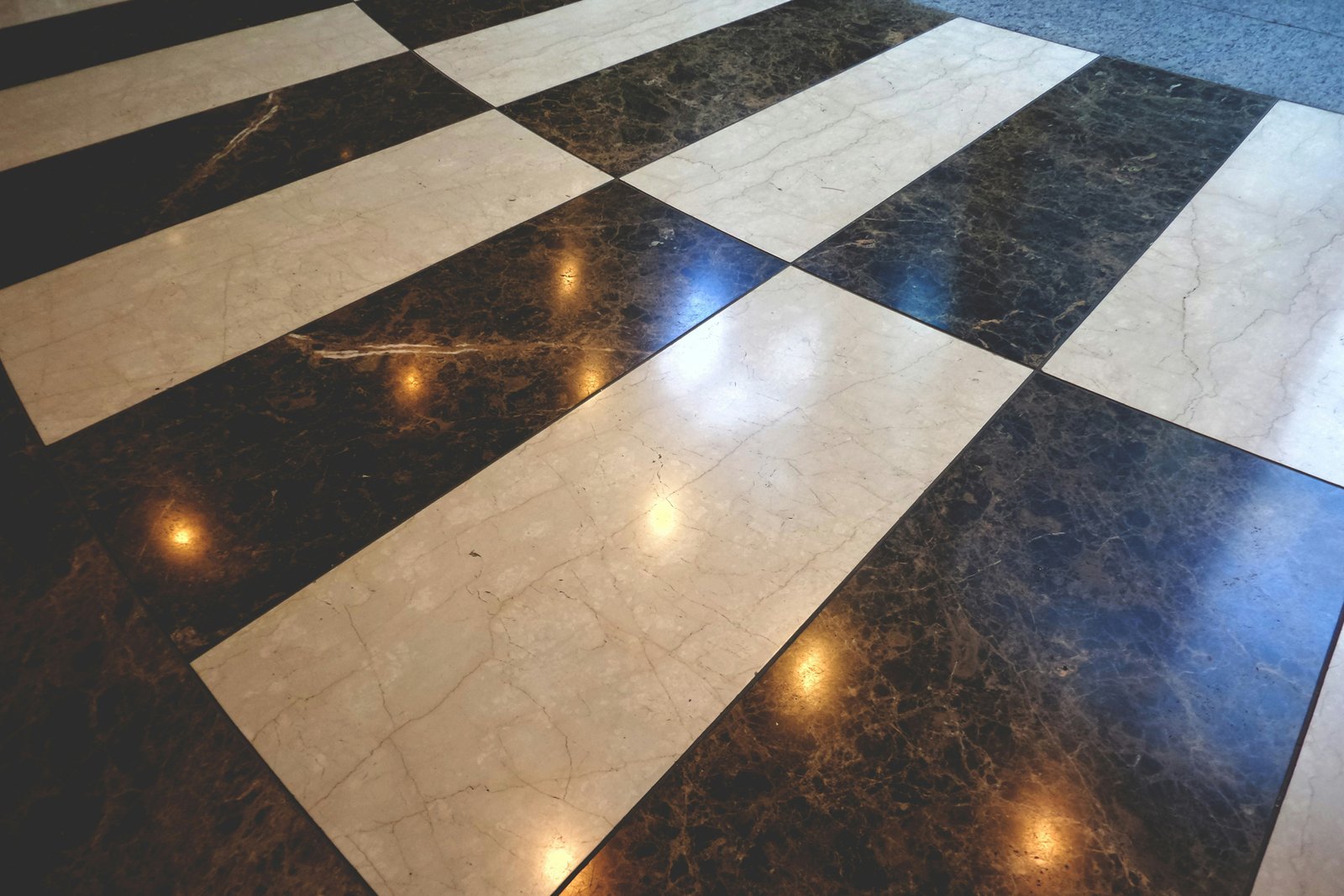 Hand trägt Reparaturmasse auf einen feinen Riss in einer Fliese auf